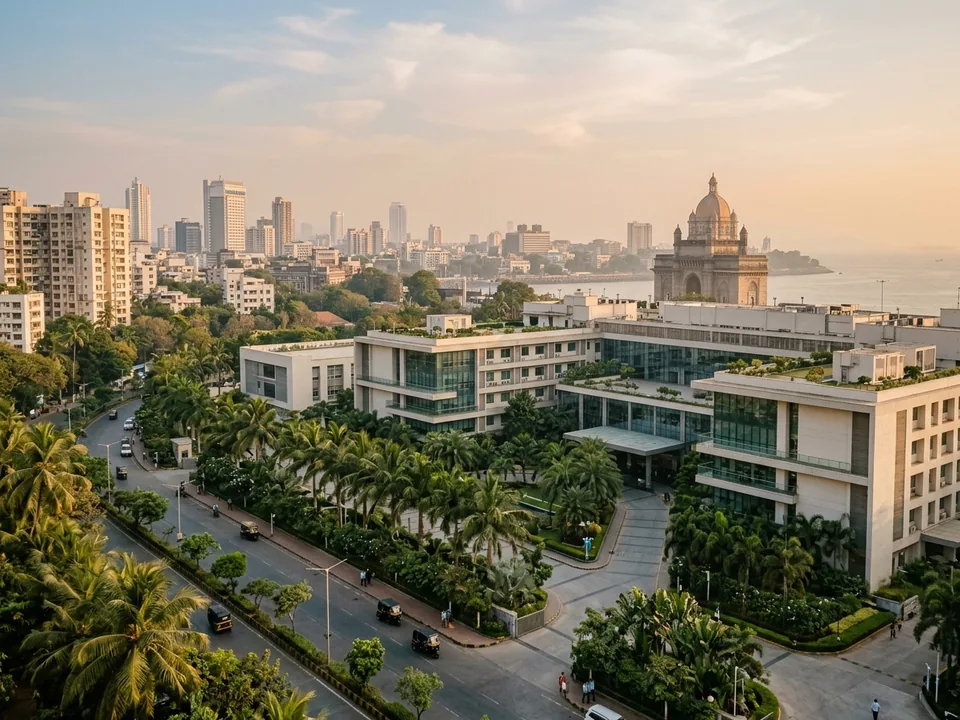 A large modern hospital campus in an Indian city with a historic monument in the distance